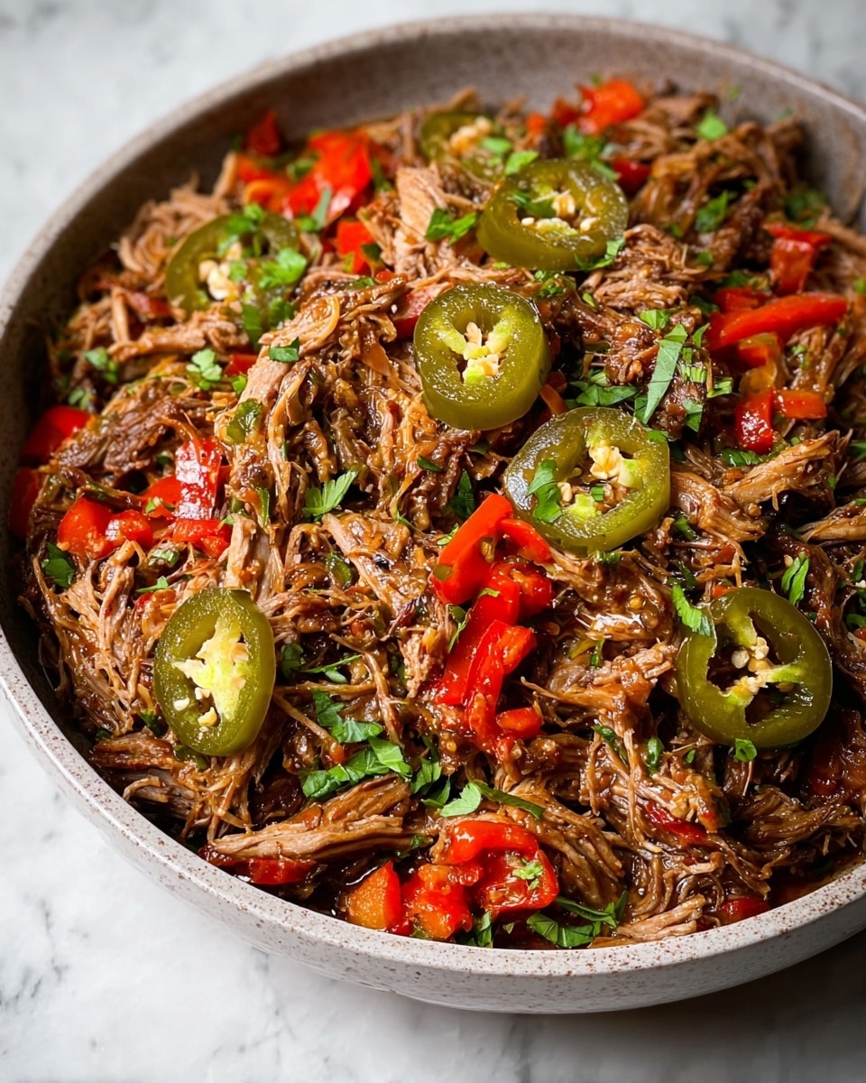 A close-up view of a large white bowl filled with a mix of shredded brown meat, scattered with juicy bright red pepper slices and round green jalapeño slices. The meat is tender and moist with visible sauce making a slightly shiny texture. Small pieces of fresh green herb leaves are sprinkled on top, adding a fresh contrast. The bowl sits on a white marbled surface, showing the dish’s rich, colorful, and textured layers clearly. photo taken with an iphone --ar 4:5 --v 7