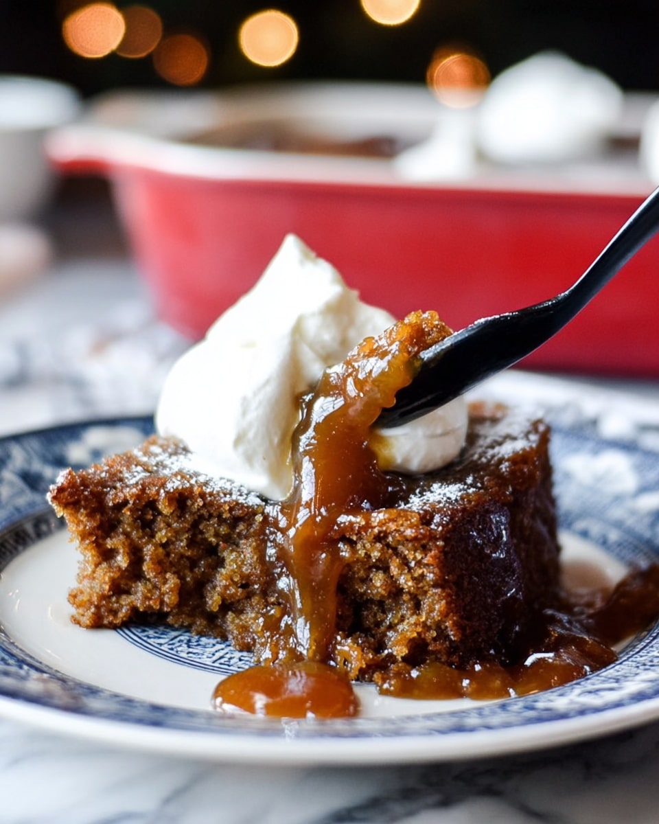 A close-up of a single slice of moist brown cake with a sticky, glossy caramel-like sauce on top and oozing down the sides, sitting on a white plate with a blue patterned design. The cake has a rough, crumbly texture and is topped with a soft, white dollop of whipped cream. A black fork is cutting into the cake, lifting some of the cream and sauce, held by a woman's hand. The background has a white marbled texture with blurred soft lights and a red baking dish visible behind. photo taken with an iphone --ar 4:5 --v 7