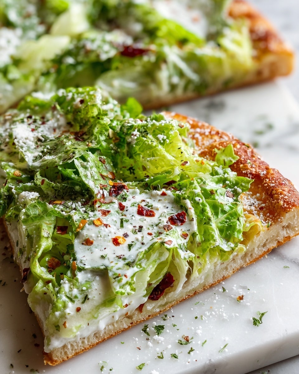 The image shows a slice of pizza with two clear layers. The bottom layer is a thin, crispy, golden-brown crust with a rough texture and some crunchy edges. On top, there is a thick layer of fresh green lettuce mixed with green herbs, coated in a creamy white sauce with small bits of white cheese sprinkled throughout. Red chili flakes and ground pepper are scattered on the lettuce for a pop of color. The pizza slice is placed on a white cutting board on a white marbled surface. Photo taken with an iphone --ar 4:5 --v 7